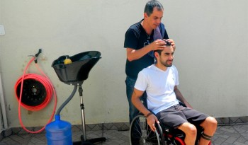 José Valente corta o cabelo de cadeirante